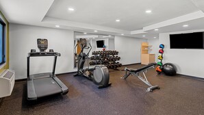 Een moderne sportschool met loopbanden, elliptische trainers en losse gewichten.