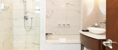 Uma casa de banho moderna com chuveiro, banheira e toucador com pia e espelho.