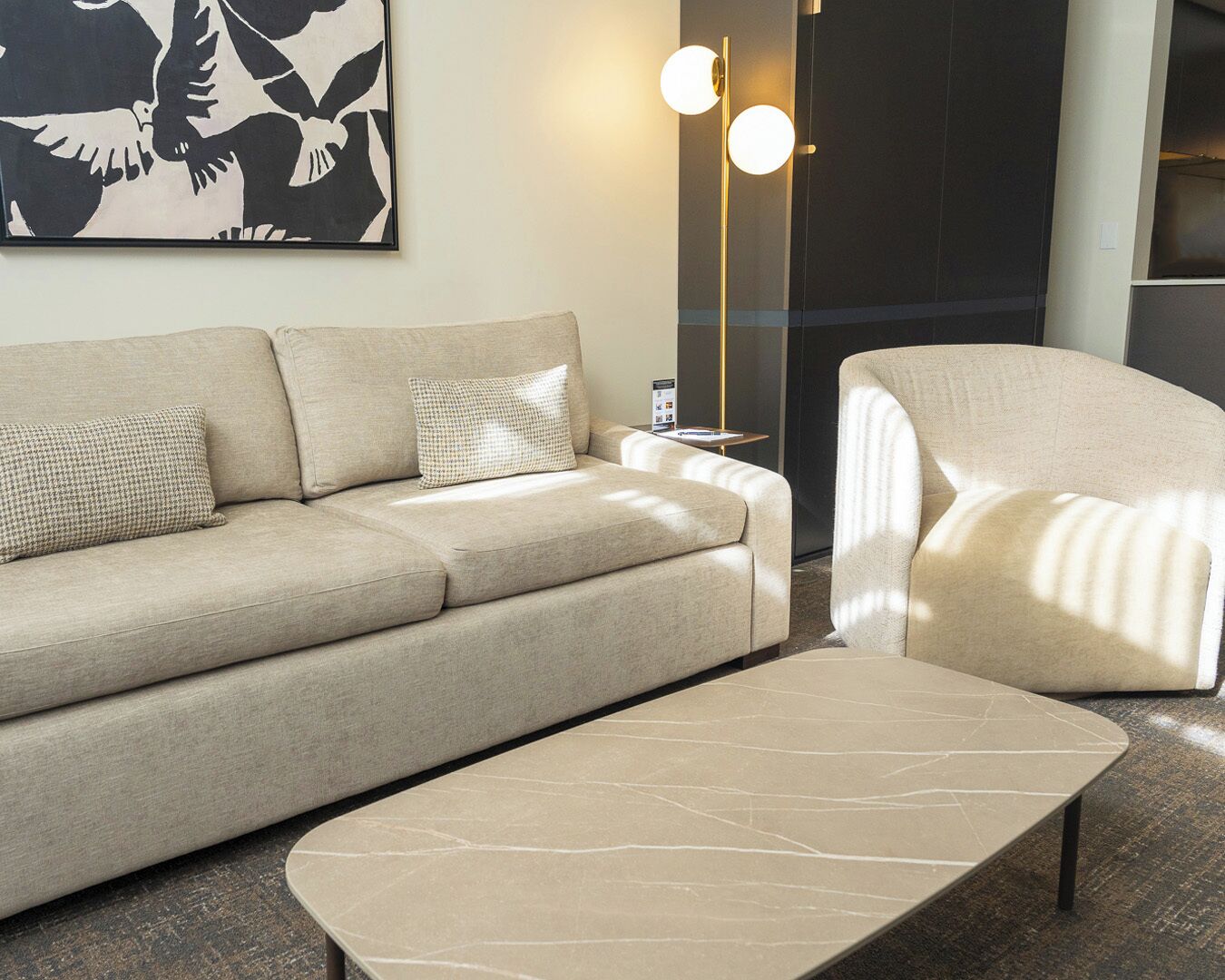 Una sala de estar moderna con sofá, sillón y mesa de centro.