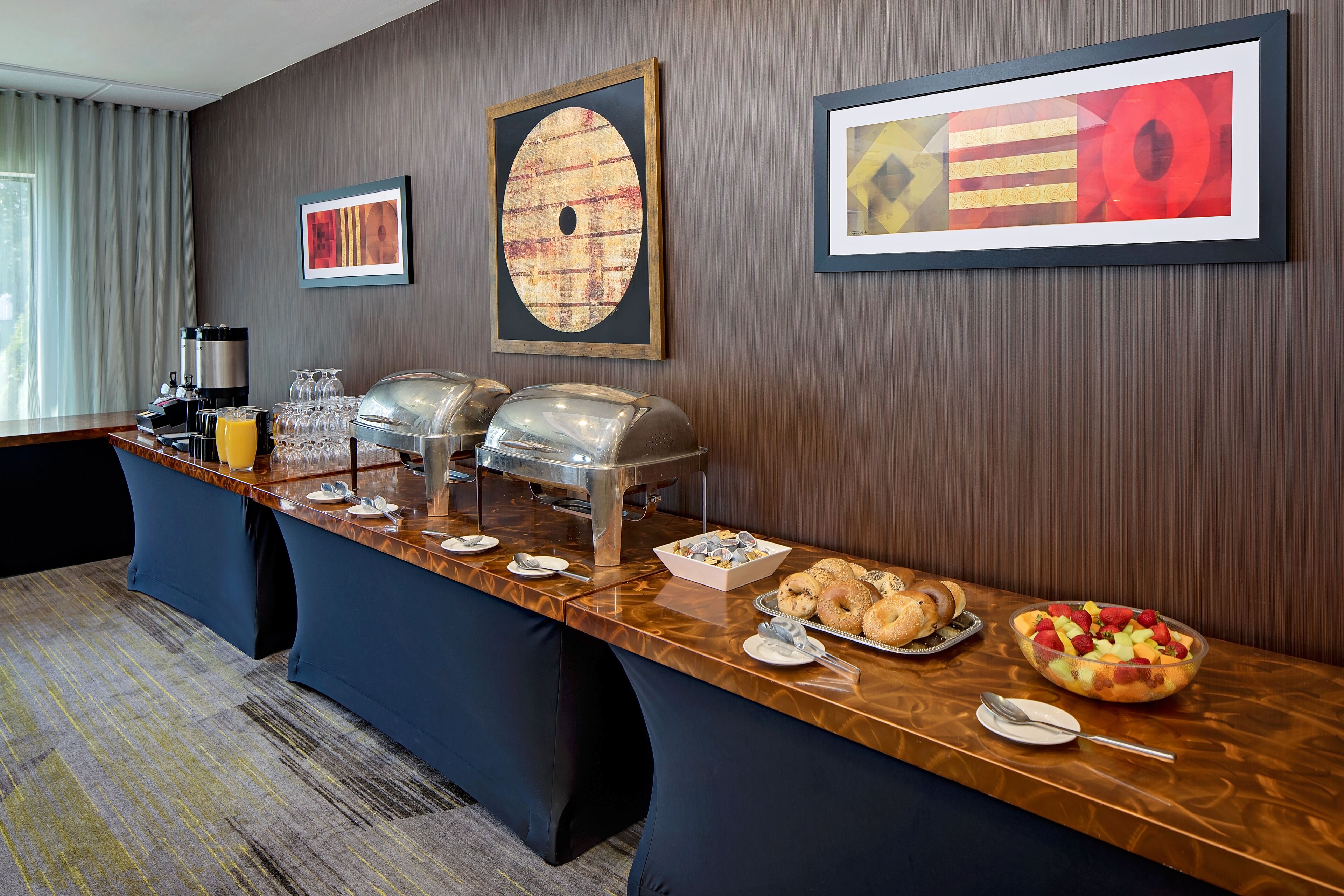 A breakfast bar with various food items, a coffee machine, and a juice dispenser.