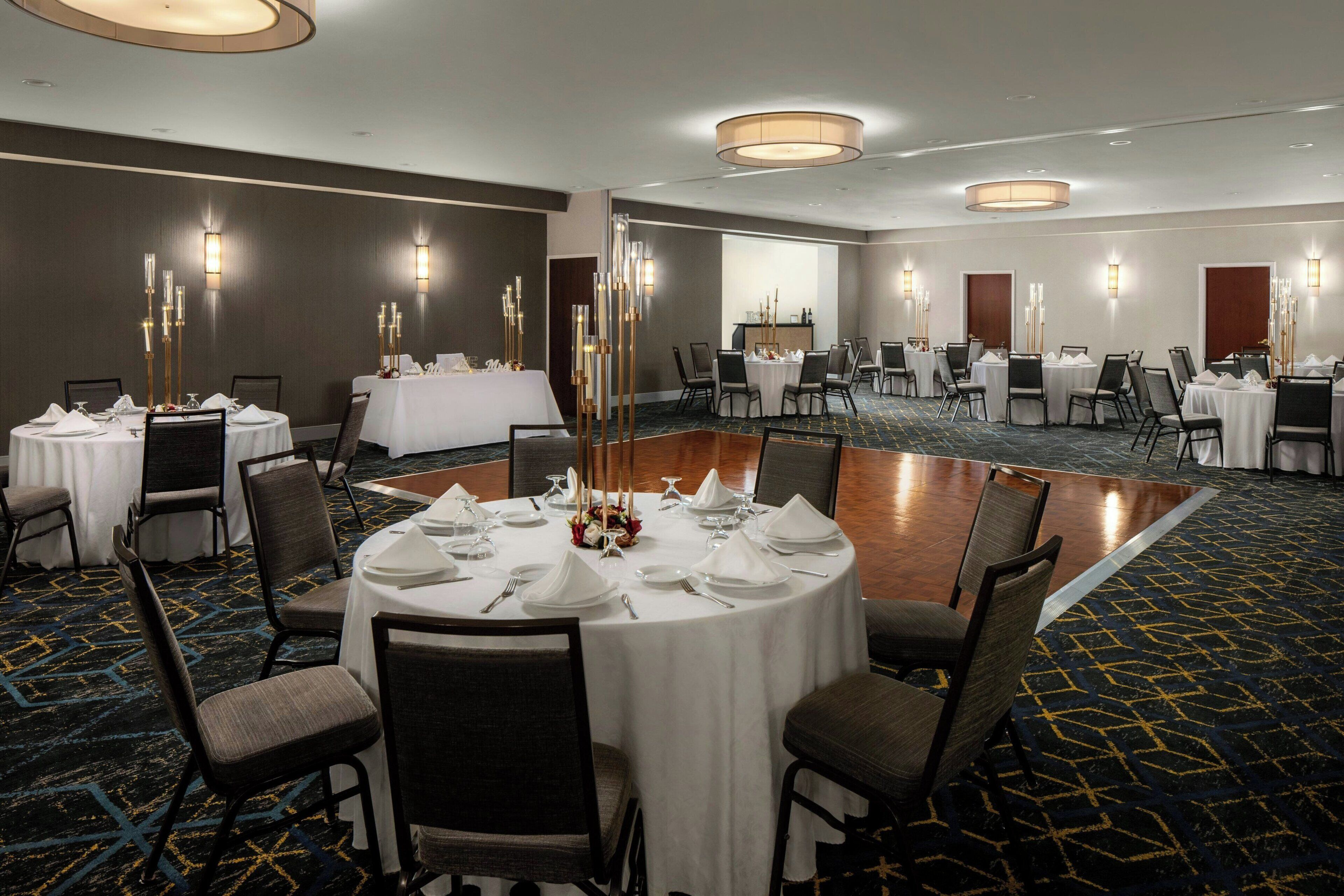 A conference room with round tables, chairs, and a large central table.