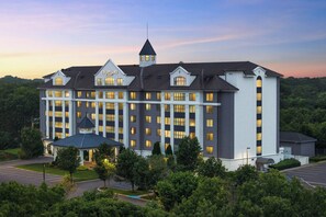 A large, multi-story hotel with a prominent tower and a covered entrance. - Courtyard by Marriott Long Island MacArthur Airport (Ronkonkoma)