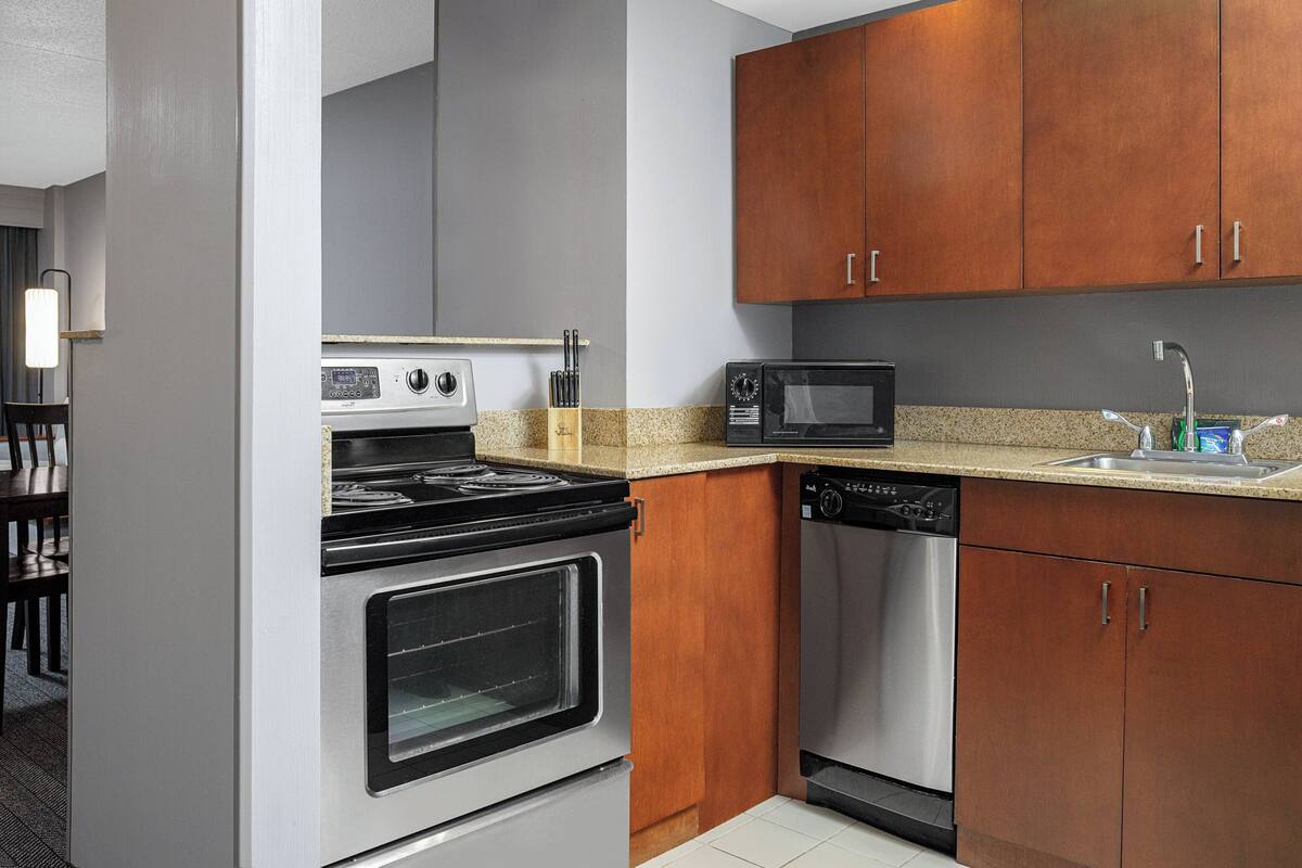 A compact kitchen with a stove, oven, microwave, and dishwasher.