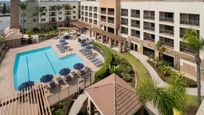 Een hotel met een zwembad, terras en een binnentuin.