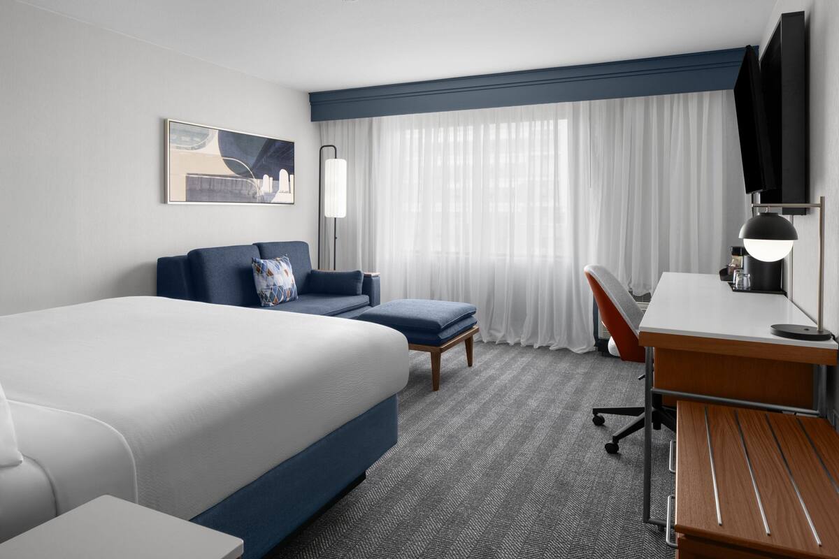 Een hotelkamer met een groot bed, een bureau, een stoel en een bank.