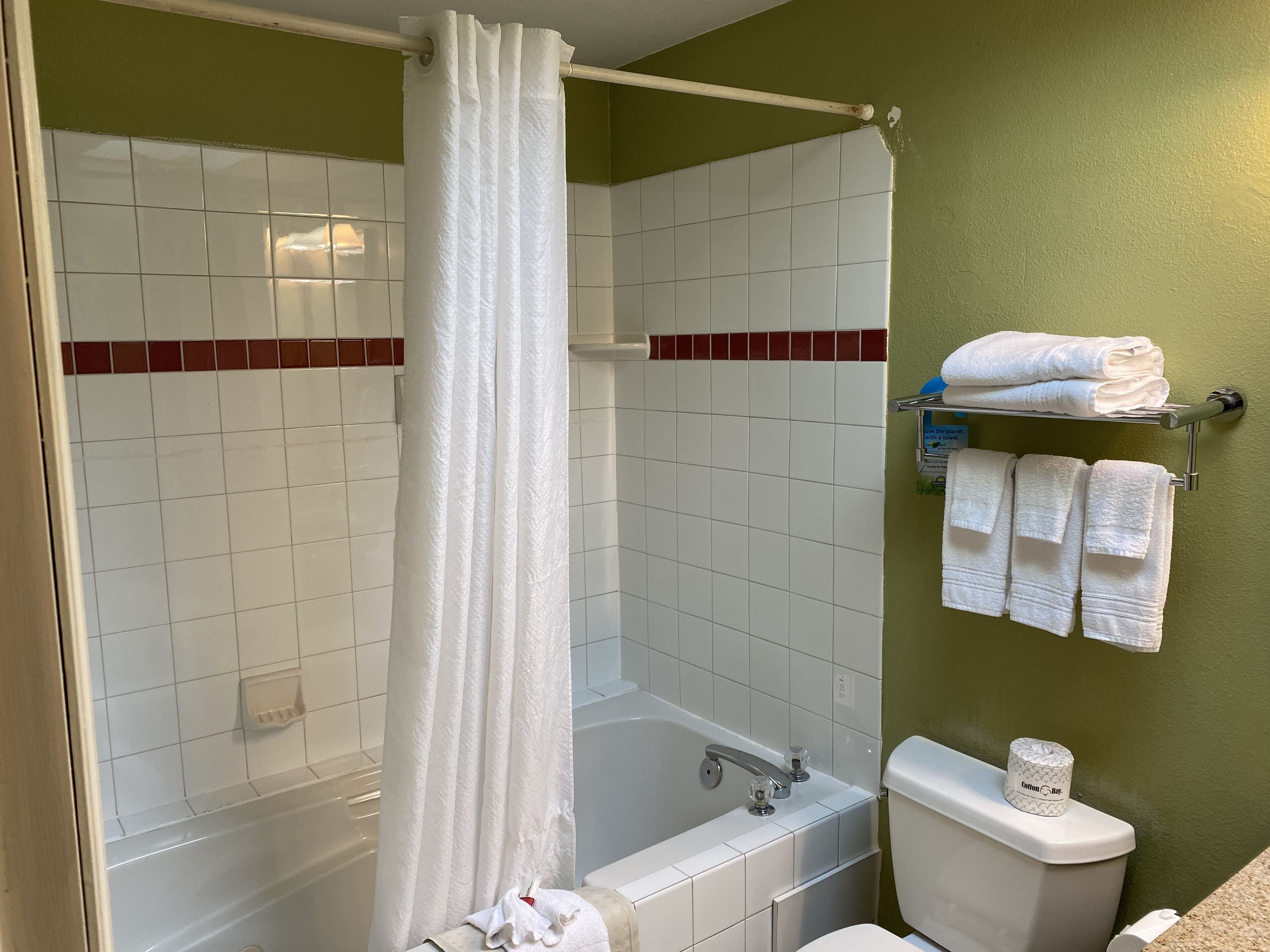 A bathroom with a bathtub, toilet, and towel rack.