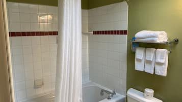 Un baño con bañera, inodoro y perchero para toallas.