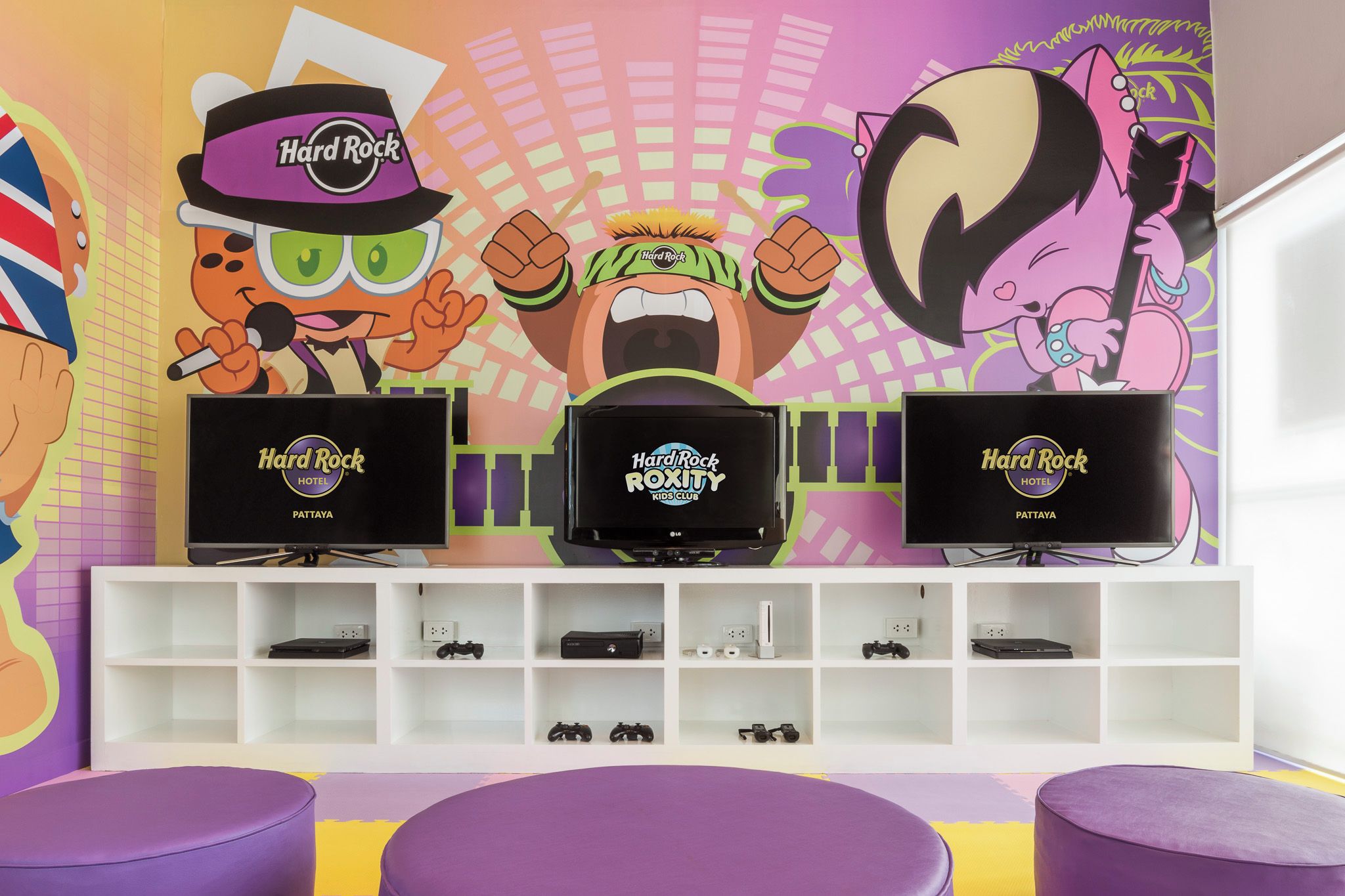 A children's room with Hard Rock-themed decor, including cartoon characters and a TV on a stand.