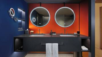 Un baño moderno con dos lavamanos, un espejo grande y un perchero para toallas.