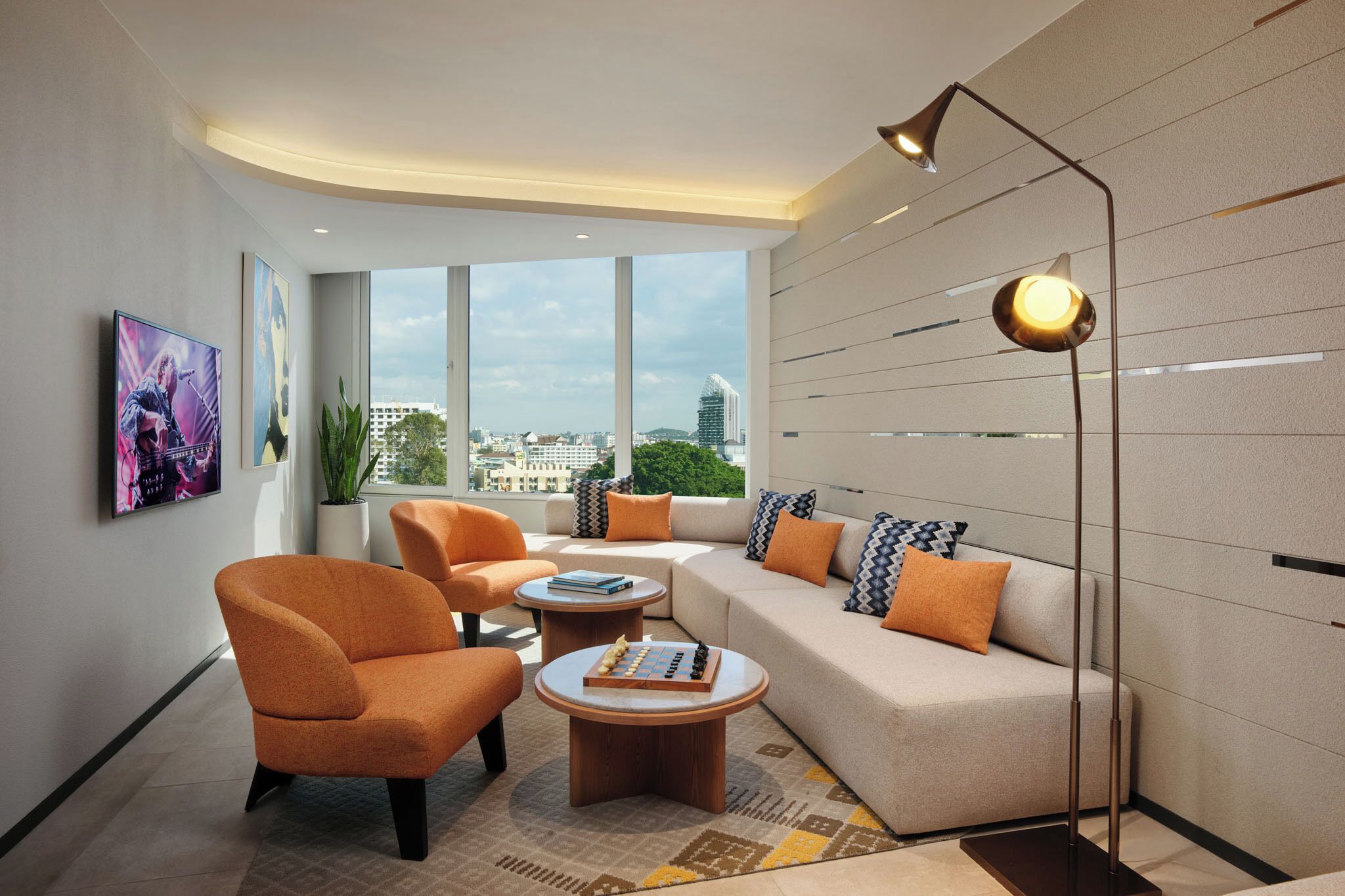 A modern living room with a sofa, armchairs, a coffee table, and a floor lamp.