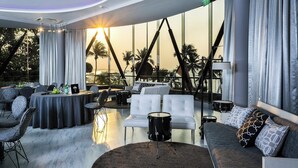 Een moderne lounge met uitzicht op de zonsondergang, zitgedeeltes en een drumstel.