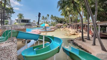 A water park with slides, palm trees, and a pool area.