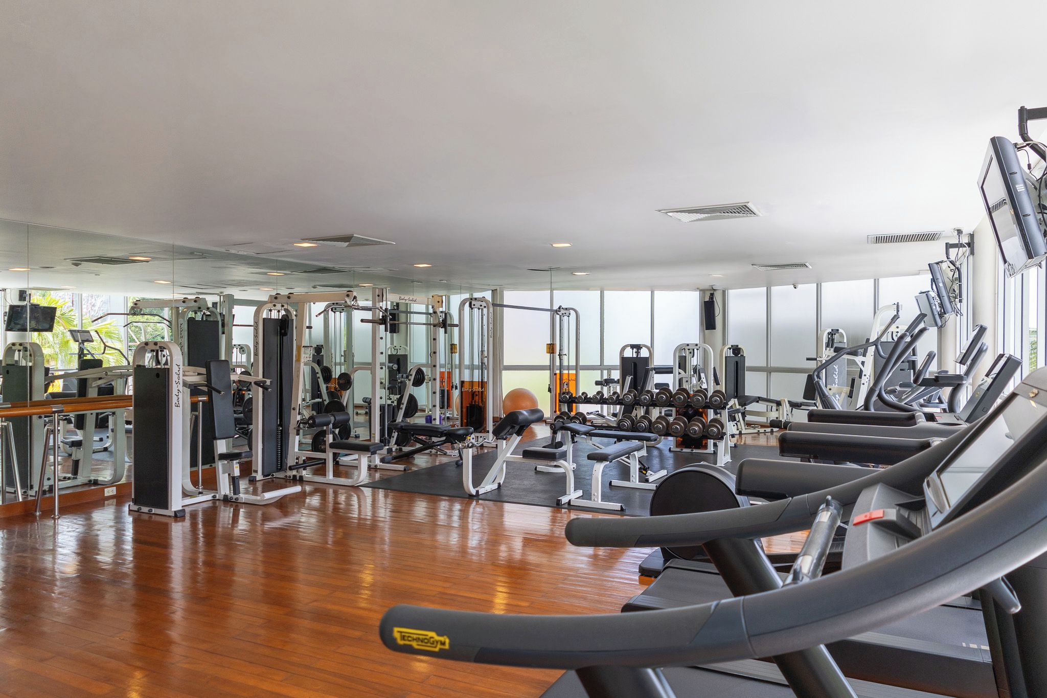 A gym with various exercise equipment, including treadmills and weight machines.