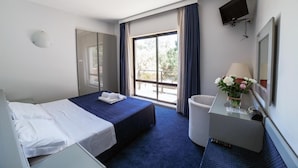 A hotel room with a bed, a desk with a lamp, a TV mounted on the wall, and a window with curtains. - Club Hotel (Mestre)