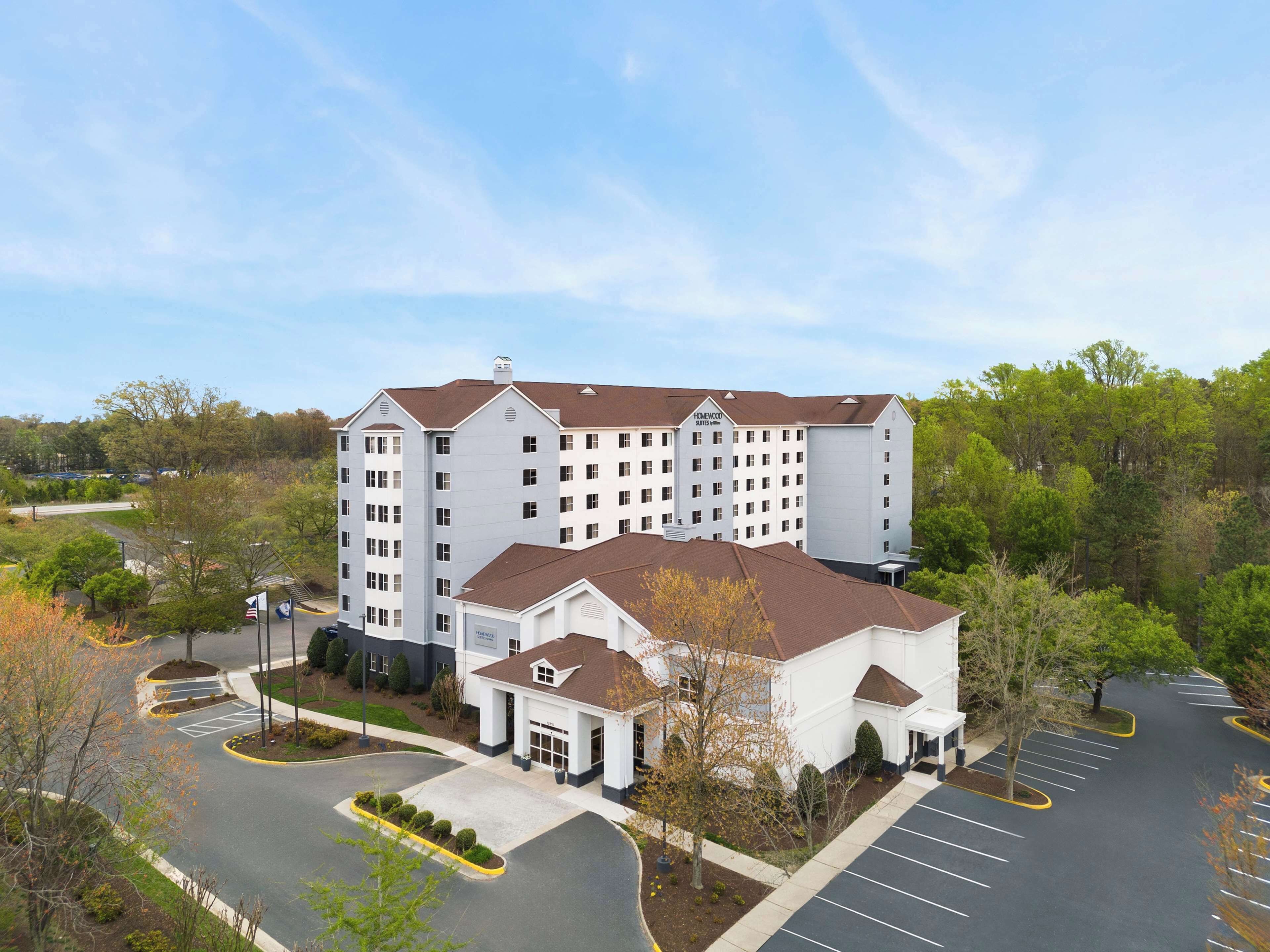 A multi-story hotel with a central courtyard and parking lot.