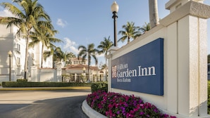 A Hilton Garden Inn sign with a clear view of the building in the background.