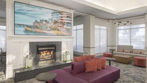 A modern living room with a fireplace, a large TV mounted above it, and a comfortable seating area with sofas and a coffee table.