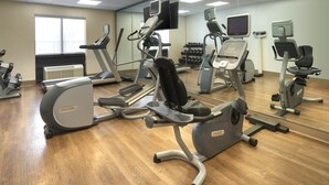A gym with various exercise equipment, including treadmills, elliptical machines, and a weight rack. - Holiday Inn Express & Suites Olive Branch by IHG (Olive Branch)