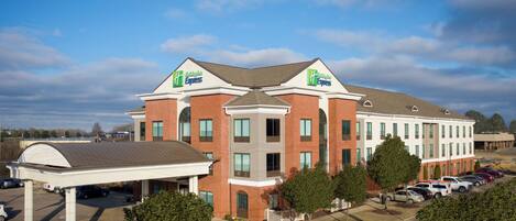A Holiday Inn Express hotel with a covered parking area and multiple cars parked in front.