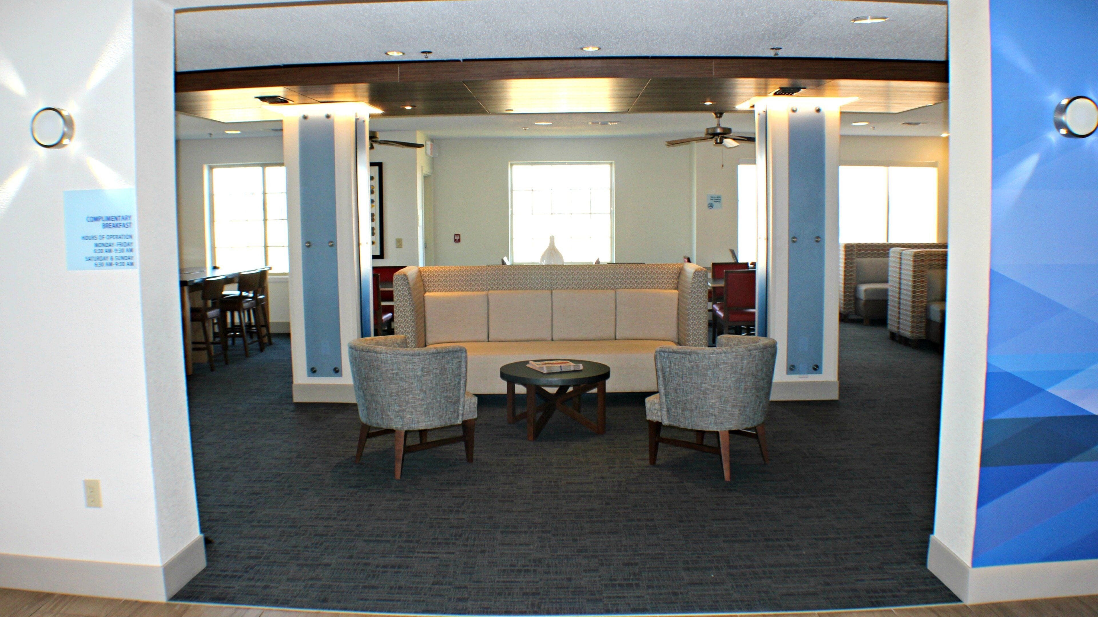 A lobby area with a seating arrangement, a small table, and a ceiling fan.