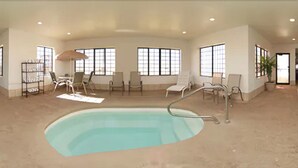 A spacious indoor swimming pool with multiple lounge chairs and a sunbed. - Holiday Inn Express & Suites Plainview by IHG (Plainview)