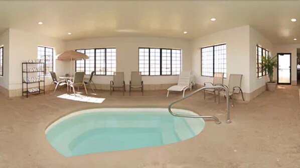 A spacious indoor swimming pool with multiple lounge chairs and a sunbed. - Holiday Inn Express & Suites Plainview by IHG (Plainview)