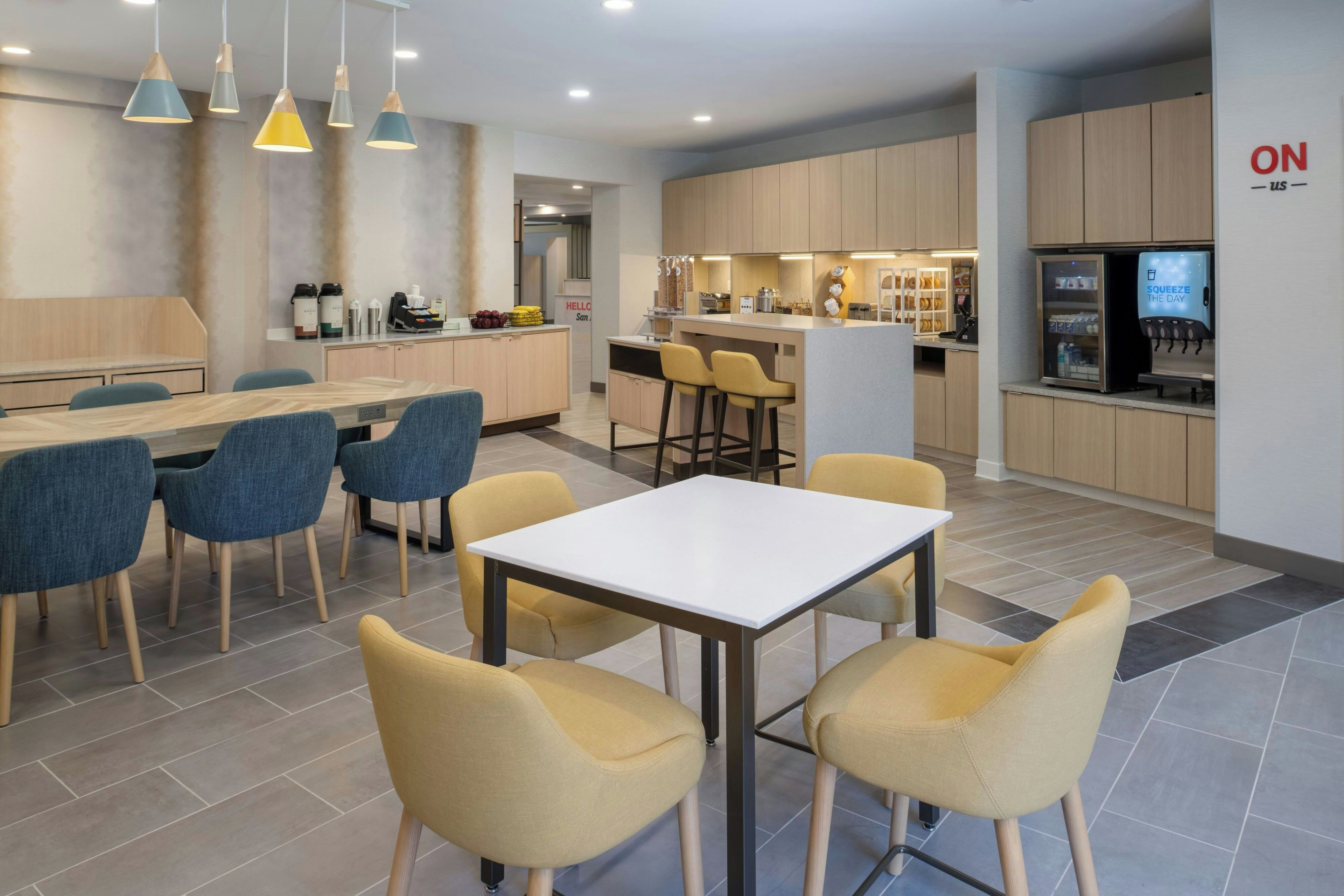 A modern kitchen with a central island, bar stools, and a coffee machine.