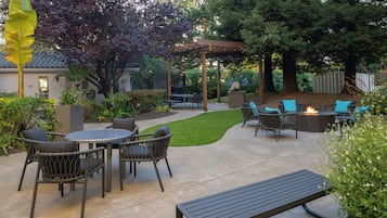 A patio with outdoor furniture, a pergola, and a fire pit.