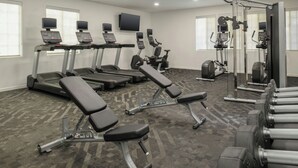 A gym with treadmills, a bench press, and a weight machine. - TownePlace Suites by Marriott San Pablo (San Pablo)