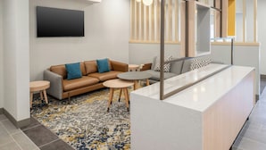 A modern living room with a sofa, coffee table, and a TV mounted on the wall.