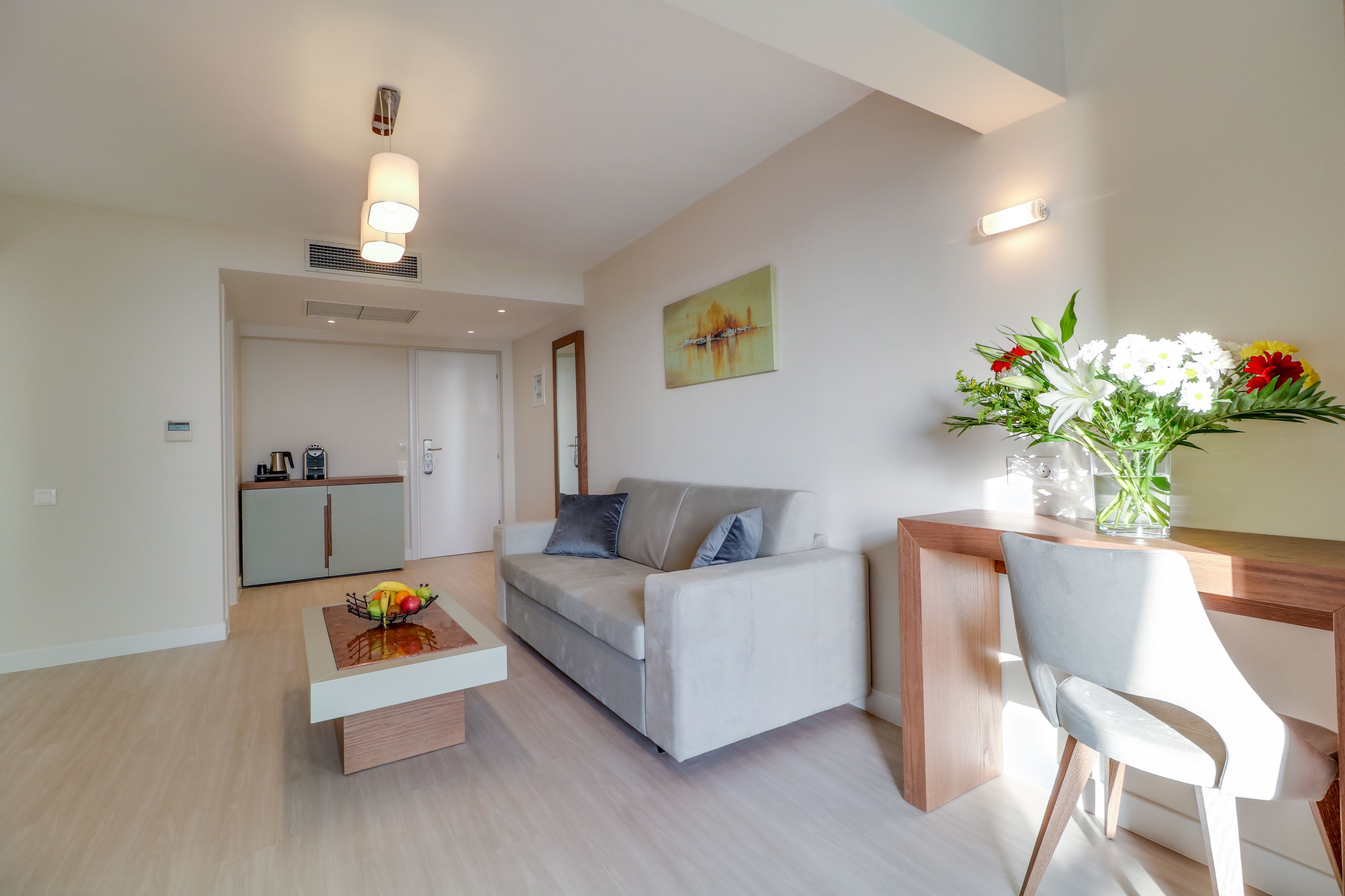 Una sala de estar moderna con un sofá, una mesa de centro y un comedor con una silla.