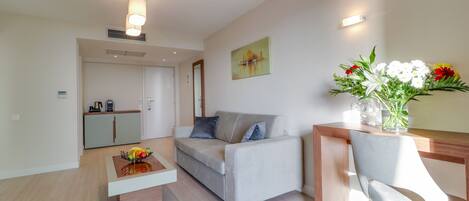 Una sala de estar moderna con un sofá, una mesa de centro y un comedor con una silla.