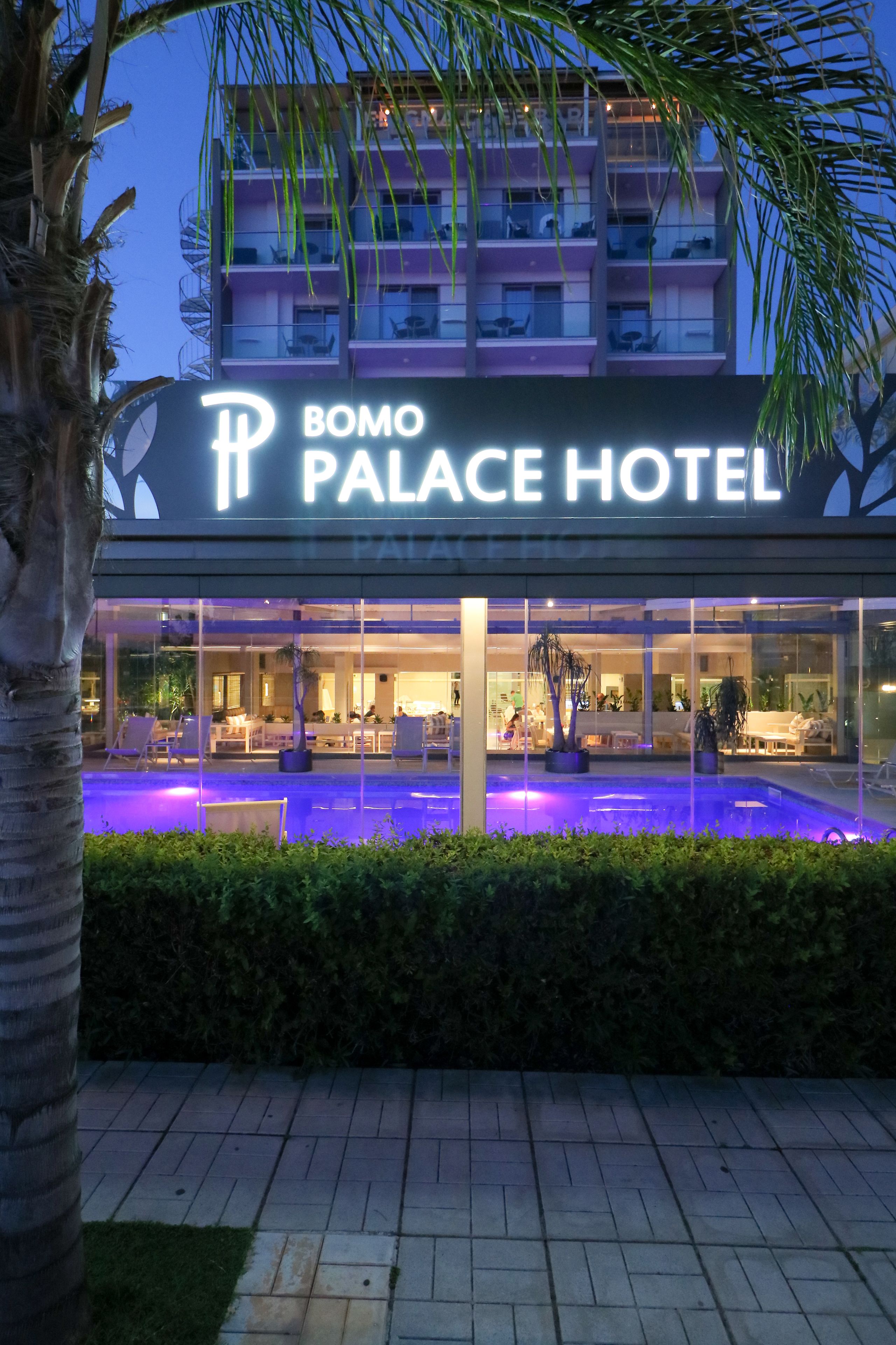 Bomo Palace Hotels facade med swimmingpool og opholdsområde.