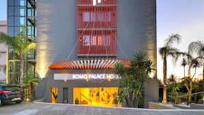 Een modern hotel met een opvallend 'P'-logo, een glazen gevel en een goed verlichte ingang.