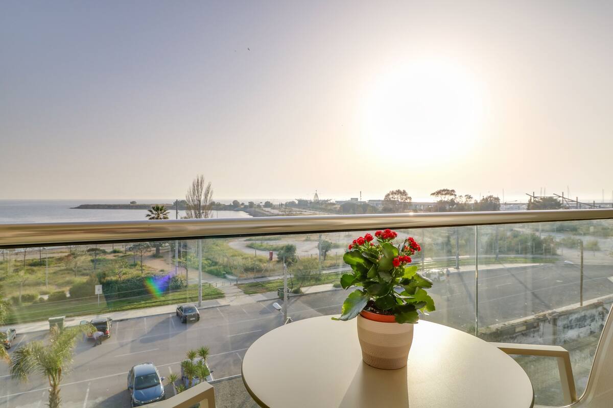 Ein Balkon mit einem Blumentopf und Blick auf eine Straße und Grünflächen.