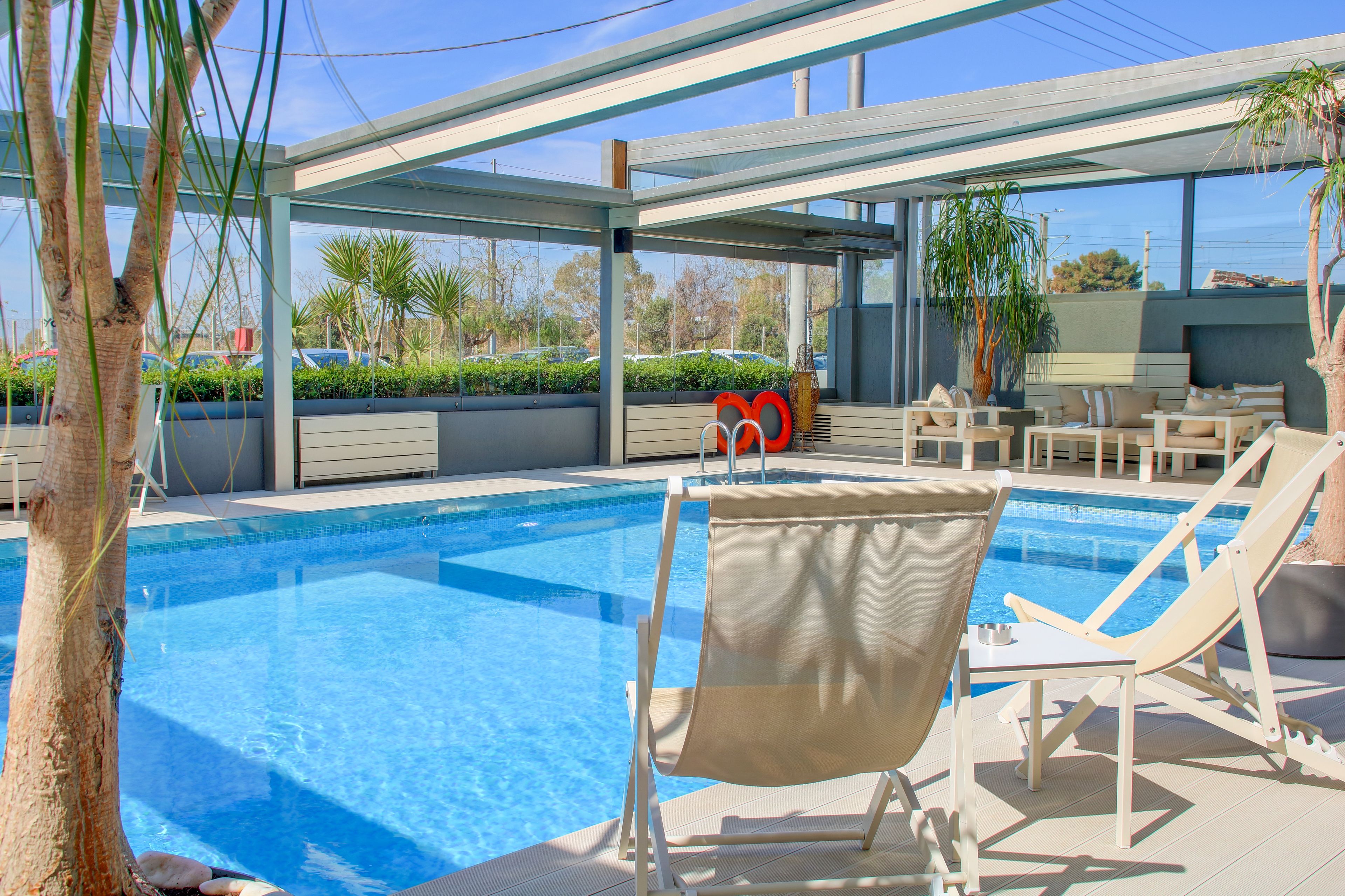 Uma área de piscina com espreguiçadeiras, um espaço de estar coberto e vista para a paisagem ao redor.