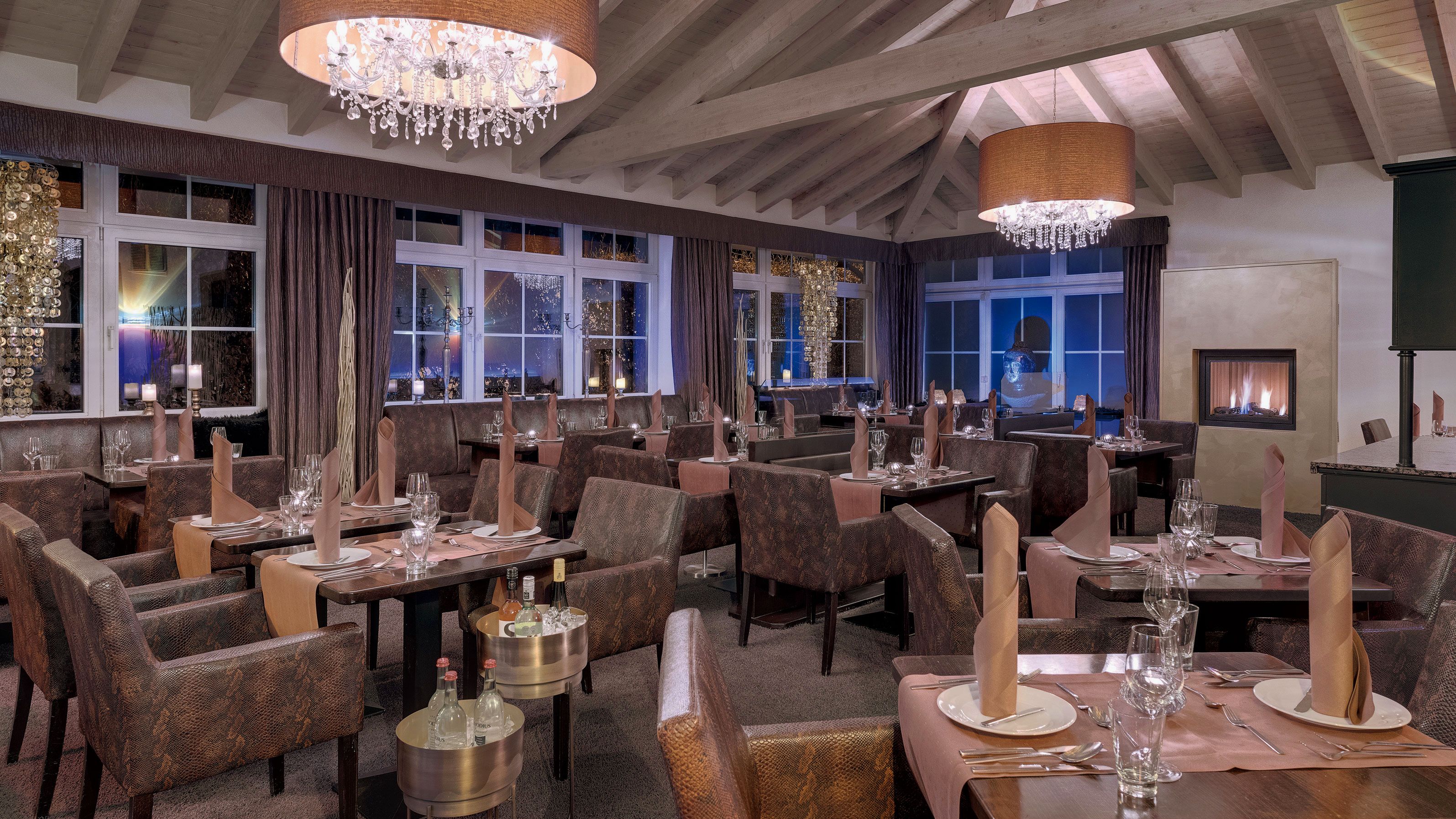 Ein Restaurant mit mehreren Tischen, Stühlen und einem Kamin.