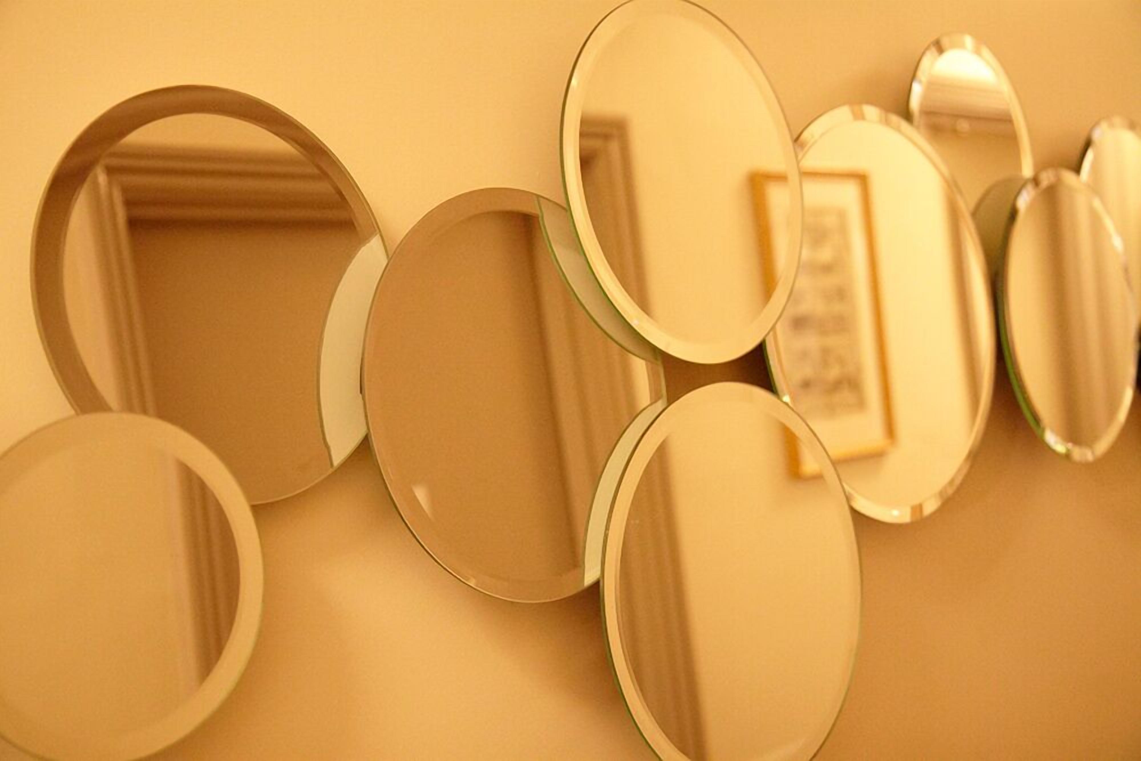 A wall with multiple round mirrors of varying sizes.