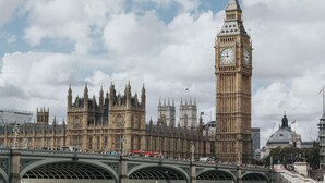A large historic building with a prominent clock tower, a bridge with arches, and a busy street scene. - The Windermere Hotel, London (London)