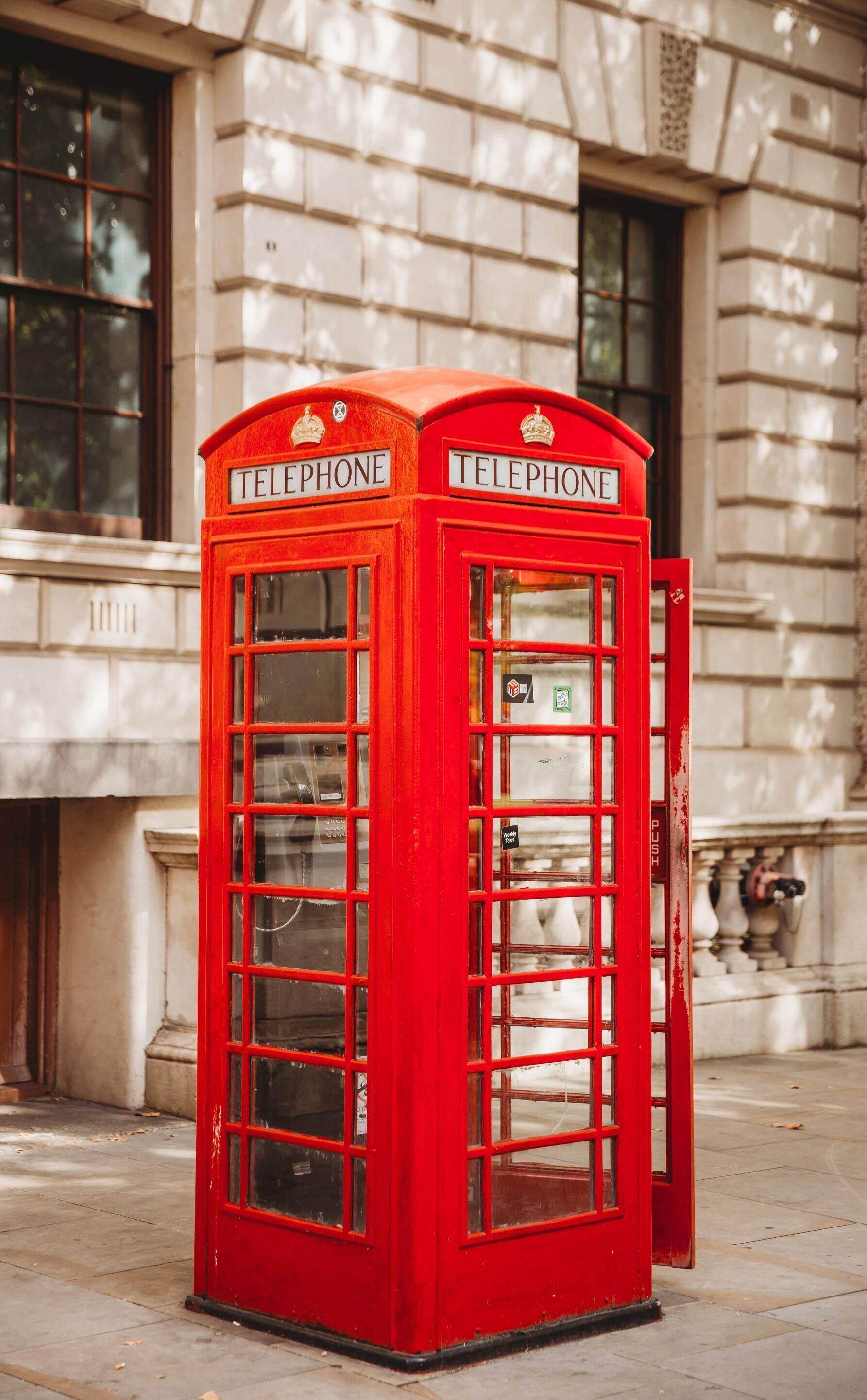 Een rode Britse telefooncel met het woord 'TELEPHONE' op de bovenkant.