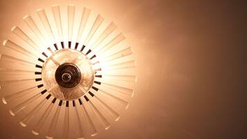 A ceiling light fixture with a circular design and multiple blades.