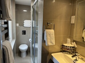 A modern bathroom with a glass-enclosed shower, a toilet, a sink with a mirror, and a towel rack. - The Windermere Hotel, London (London)