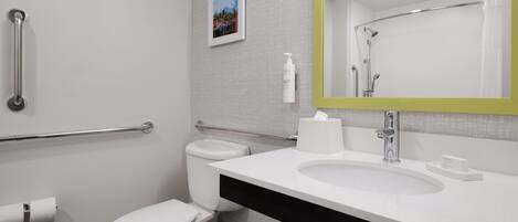 A modern bathroom with a white toilet, a sink, and a mirror with a green frame.