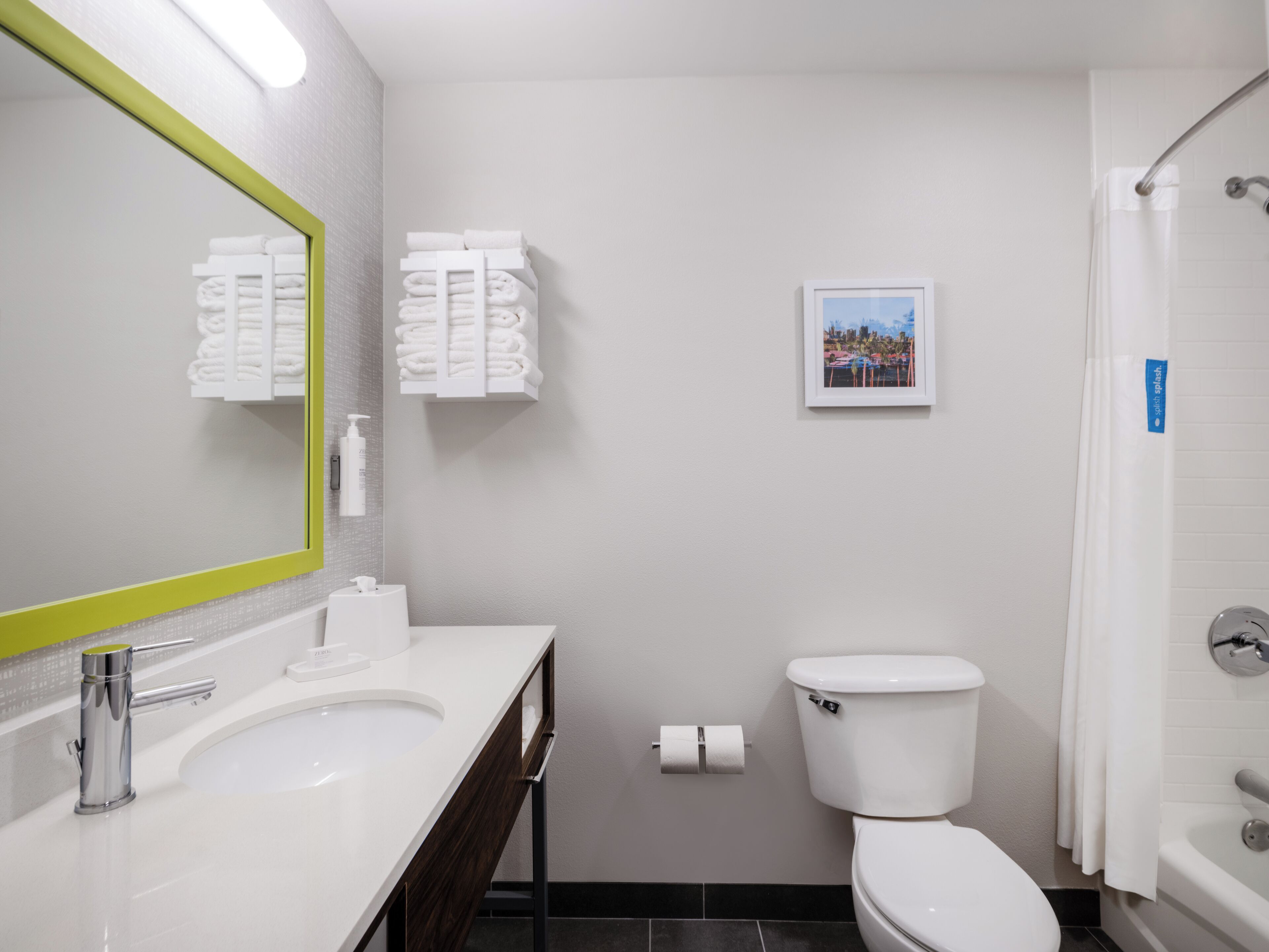A modern bathroom with a white sink, a toilet, and a shower.