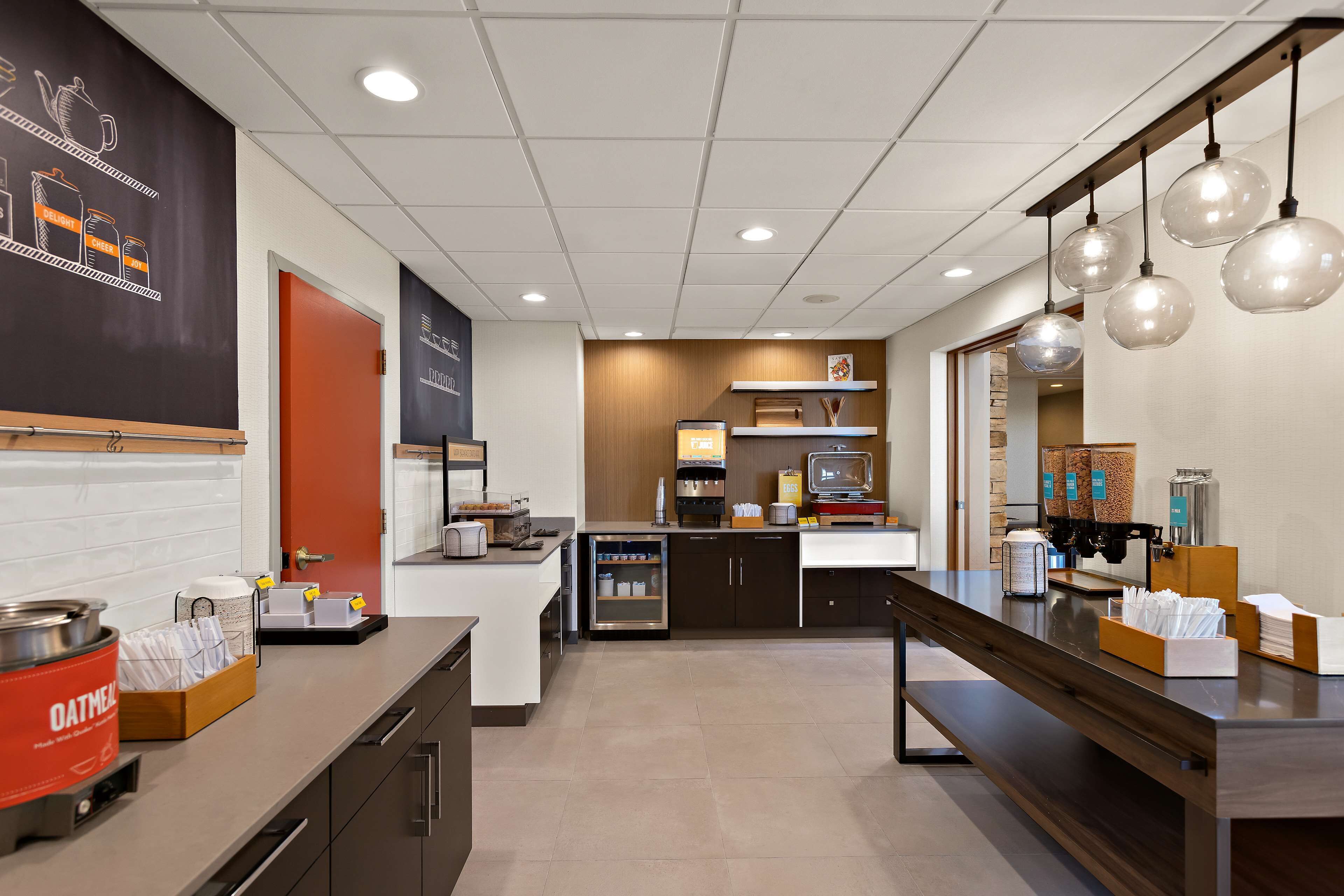 Un área de cocina moderna con una cafetera, un refrigerador y una encimera con varios objetos.
