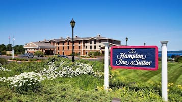 Une enseigne Hampton Inn & Suites avec vue sur l’hôtel et la végétation environnante.