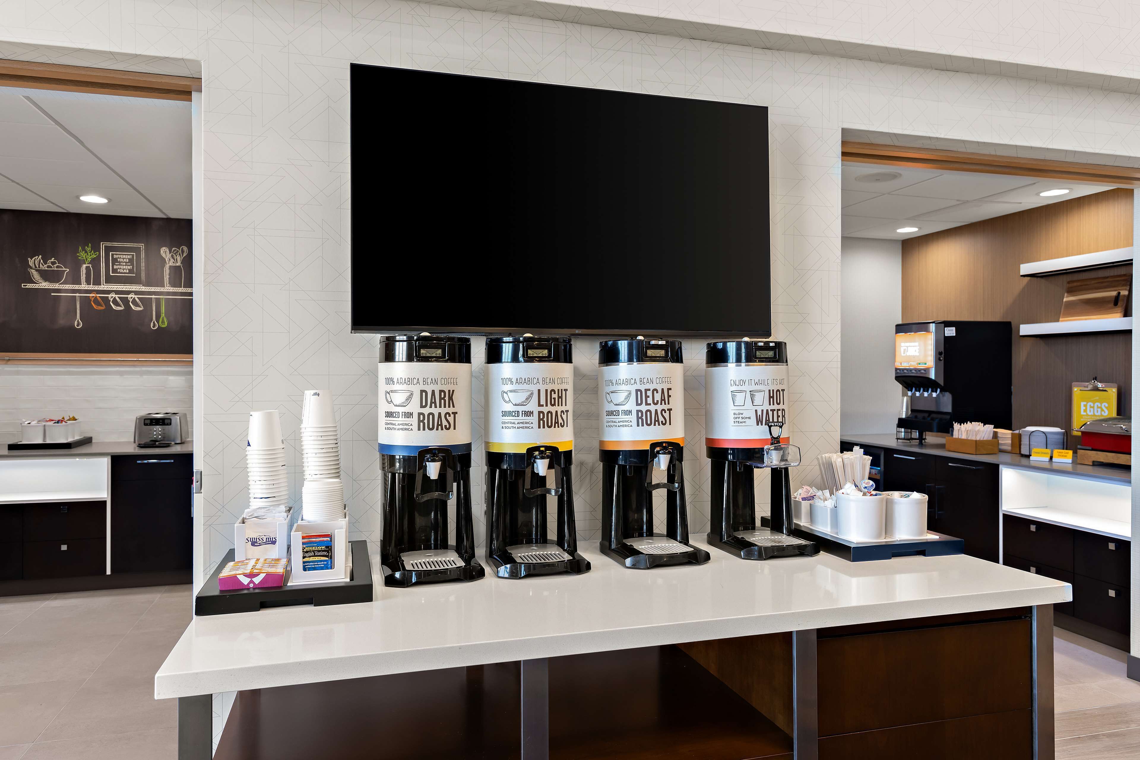 A coffee station with multiple coffee dispensers labeled with different roast types.
