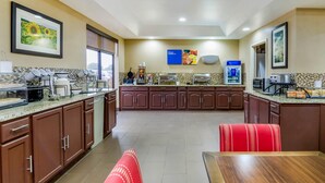 Cozinha moderna com bancadas de granito, eletrodomésticos de aço inoxidável e um balcão de refeições.