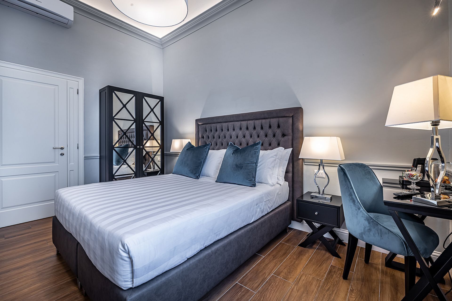 Une chambre d’hôtel moderne avec un grand lit, un bureau avec une chaise et une table de chevet.