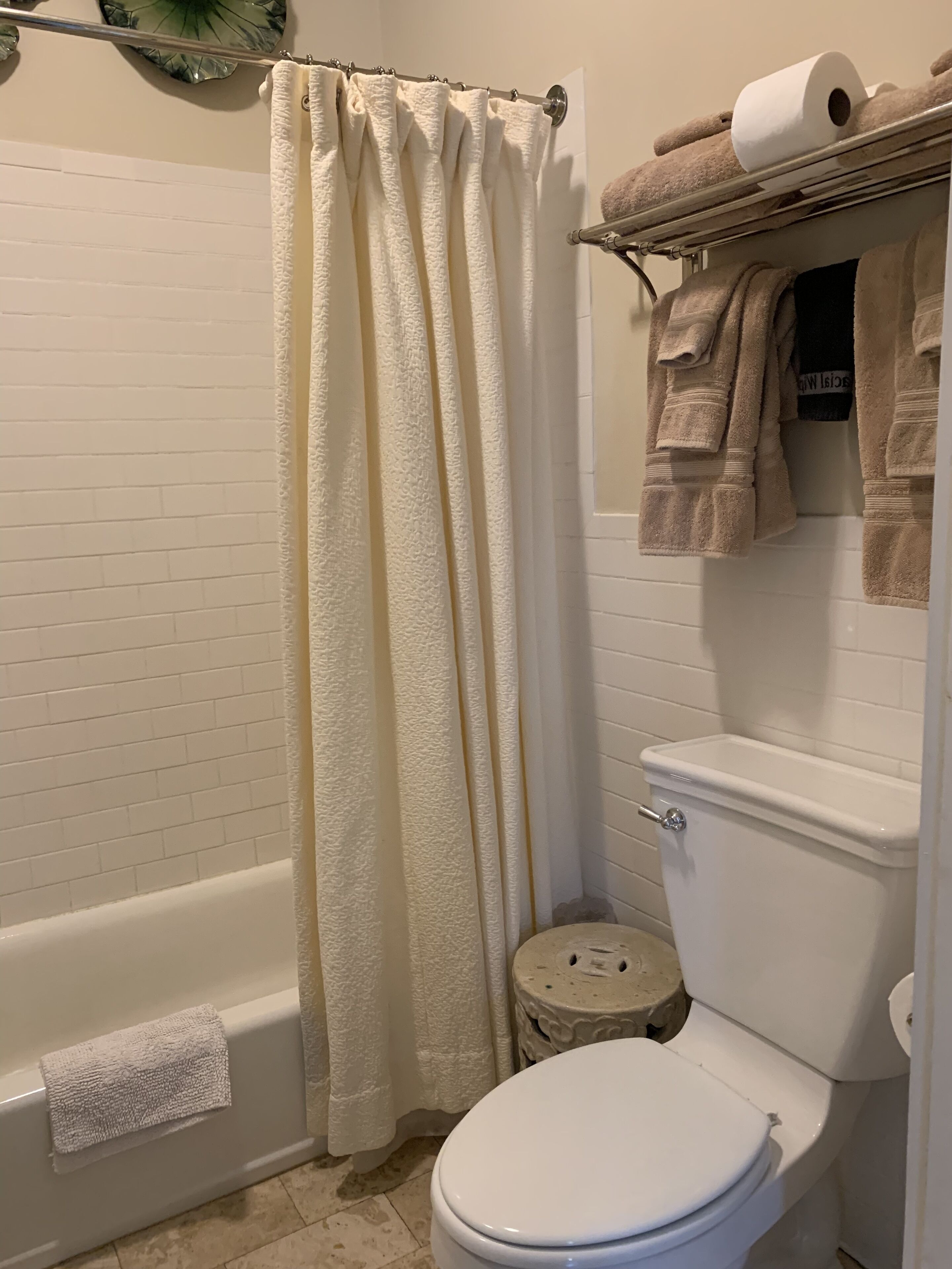 A bathroom with a bathtub, toilet, and a shower curtain.